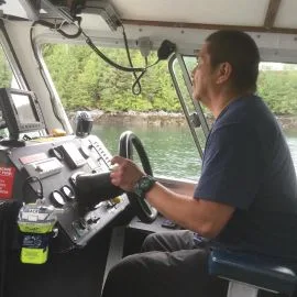 Spirit Bear Lodge boat captain drives crew boat in the Great Bear Rainforest